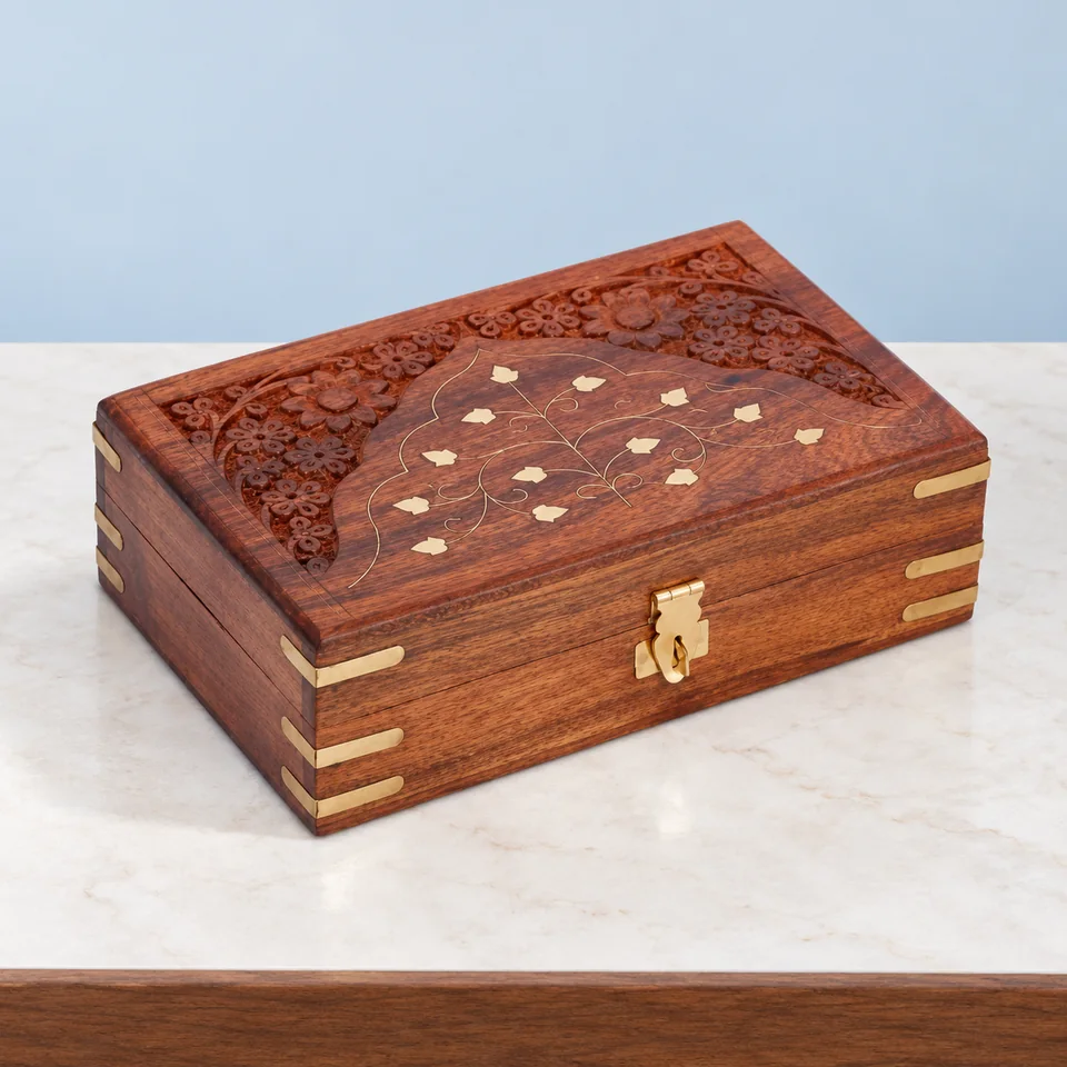 Ajuny — coffret en bois sculpté et décor floral de Ajuny, mise en situation dans un décor de pierre perle claire et de bleu ardoise pâle