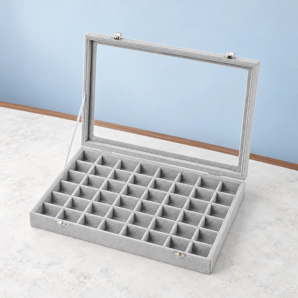 Frebeauty — coffret gris à 48 cases de Frebeauty, mise en situation dans un décor de pierre perle claire et de bleu ardoise pâle
