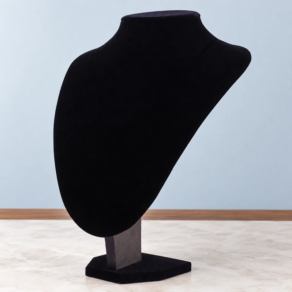 Buste pour collier en velours noir de MINGZE, mise en situation dans un décor de pierre perle claire et de bleu ardoise pâle