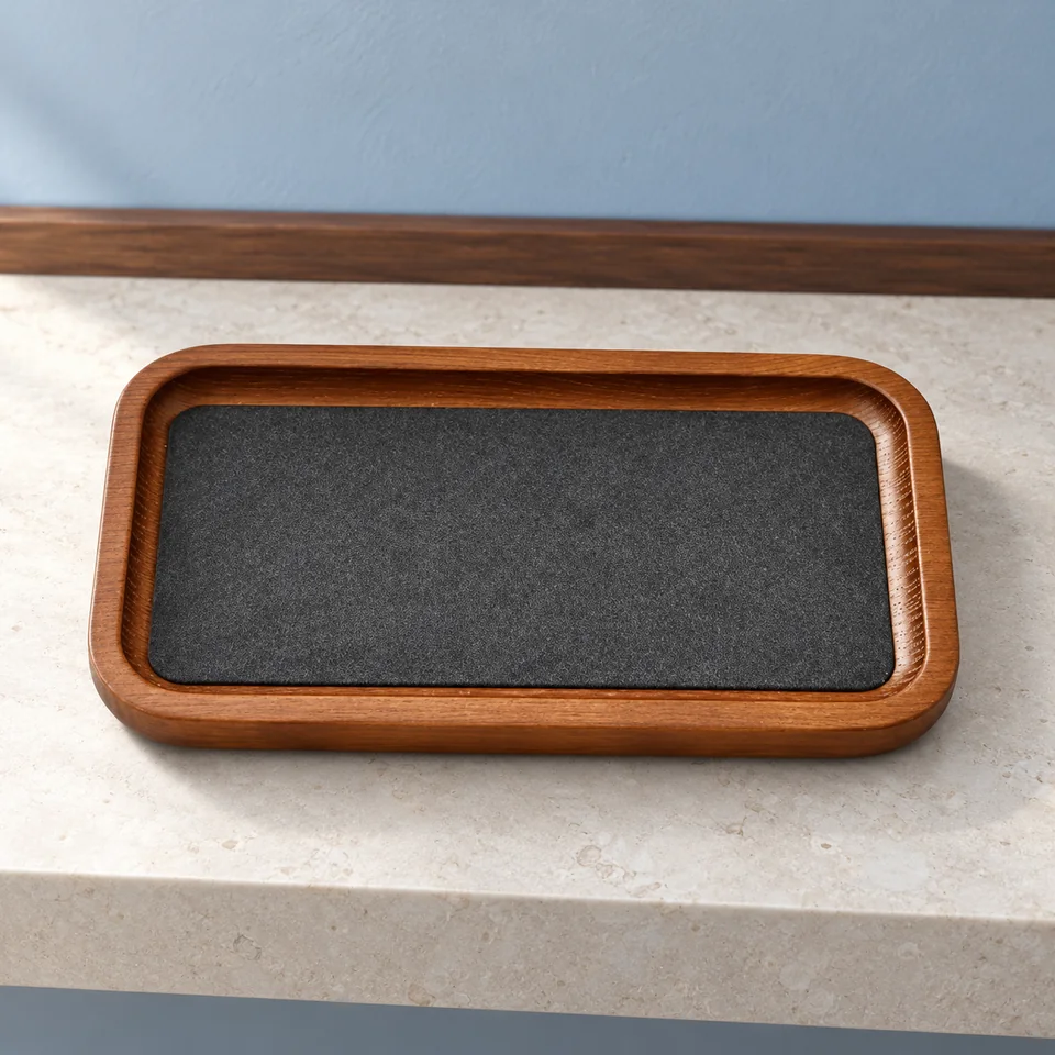 Oirlv — vide-poche bois et microfibre de Oirlv, mise en situation dans un décor de pierre perle claire et de bleu ardoise pâle
