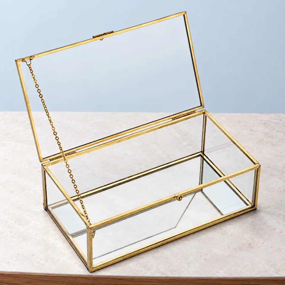 OLegei — coffret transparent à cadre doré de OLegei, mise en situation dans un décor de pierre perle claire et de bleu ardoise pâle