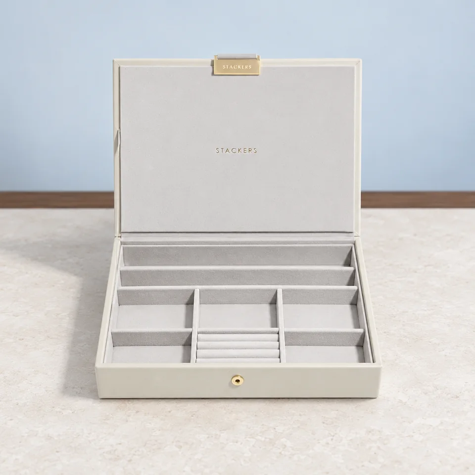 Stackers — coffret Classic Oatmeal de Stackers, mise en situation dans un décor de pierre perle claire et de bleu ardoise pâle