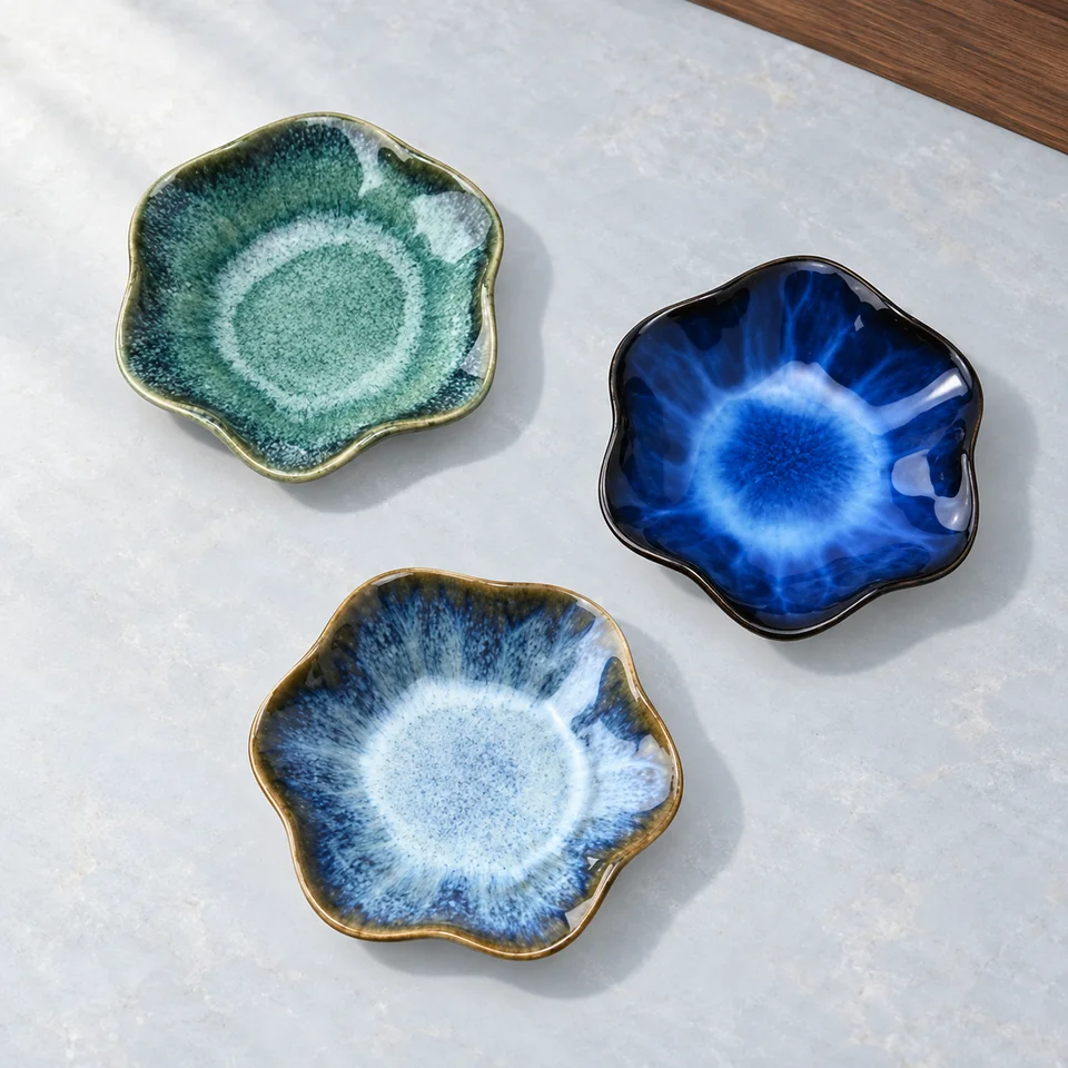 YoHyien — trois coupelles fleurs de YoHyien, mise en situation dans un décor de pierre perle claire et de bleu ardoise pâle